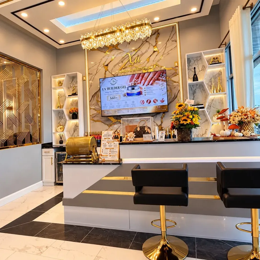 Reception desk and gold feature wall inside Xu Nails &amp; Lashes in Watertown, NY